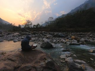 person sitting by the river